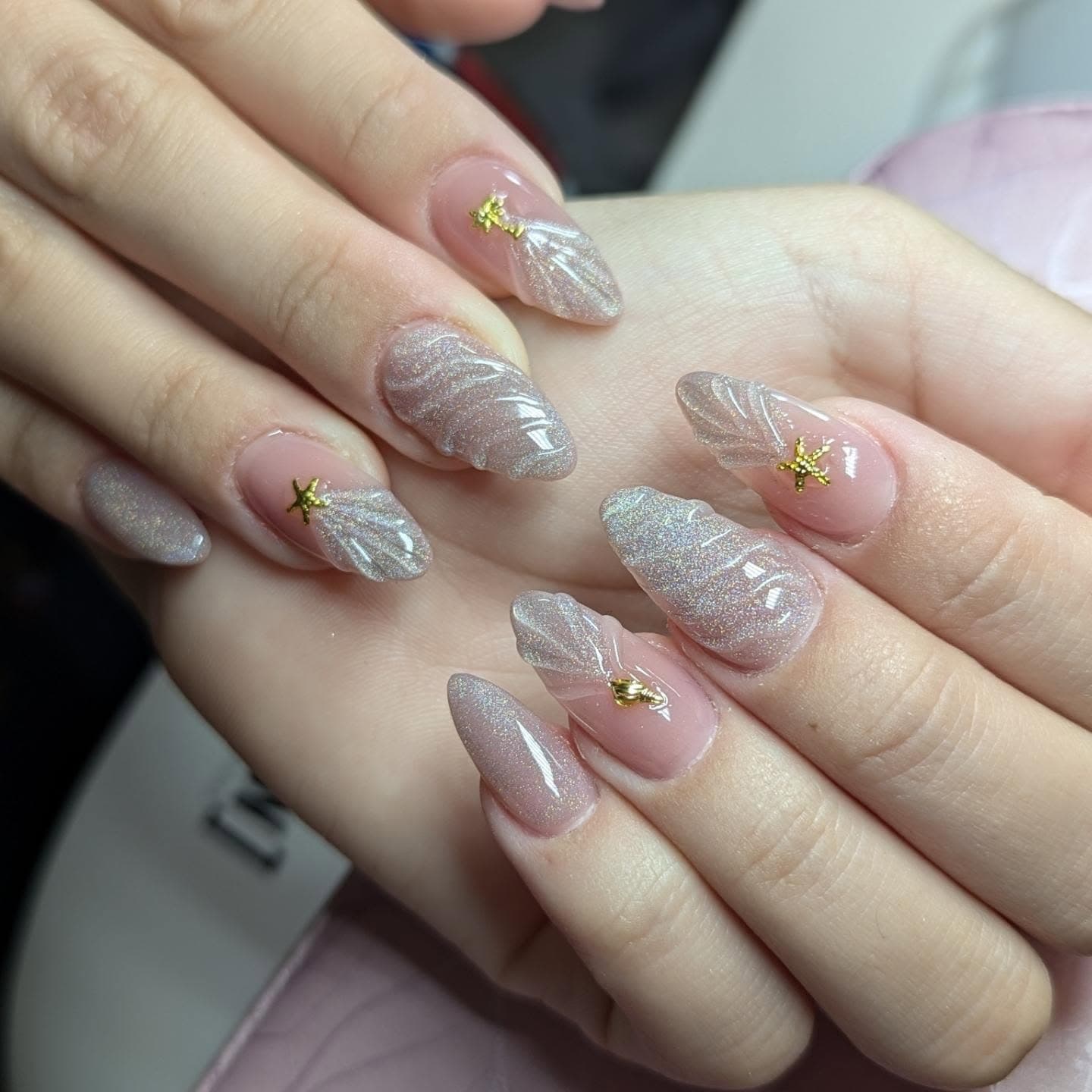 Soft pink polished nails with shell-inspired detail